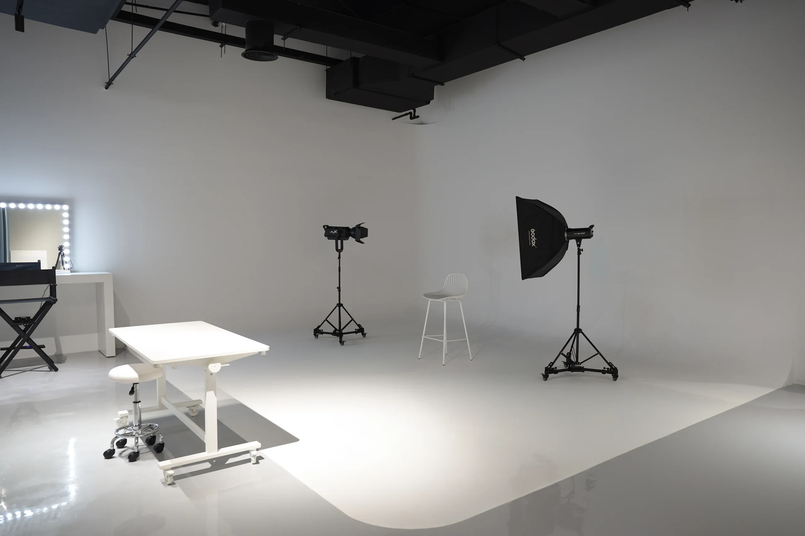 Arteo’s seamless white infinity hall: an edgeless cyclorama with two lighting stands, a shooting table and a makeup mirror.